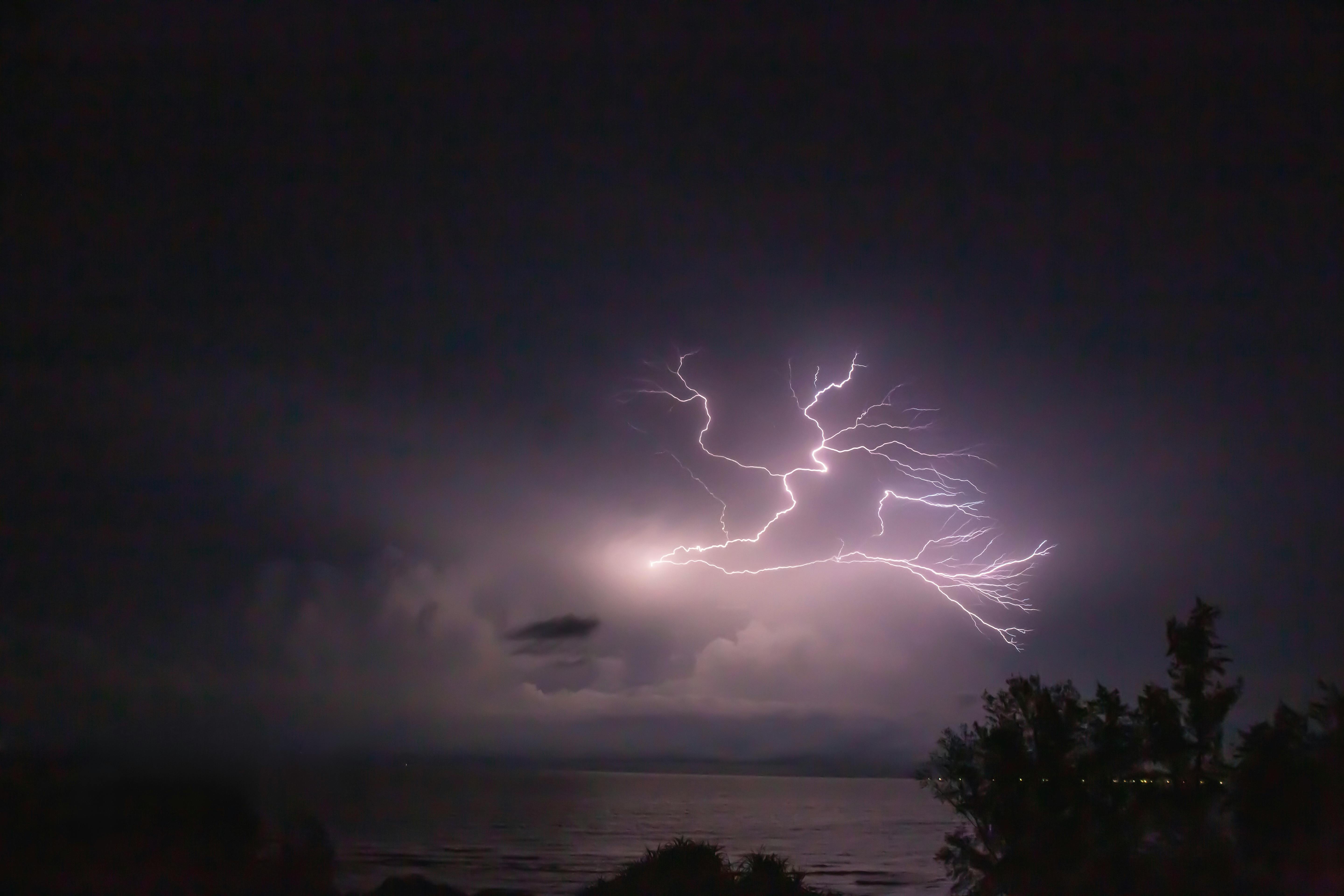 在夜间，海洋上空捕捉到了戏剧性的闪电，照亮了天空