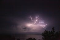 在夜间，海洋上空捕捉到了戏剧性的闪电，照亮了天空