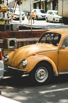 Vintage beetle car parked on a city street, showcasing nostalgic charm.