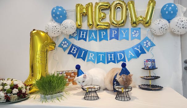 Two cats enjoy a festive birthday party complete with decorations and treats.