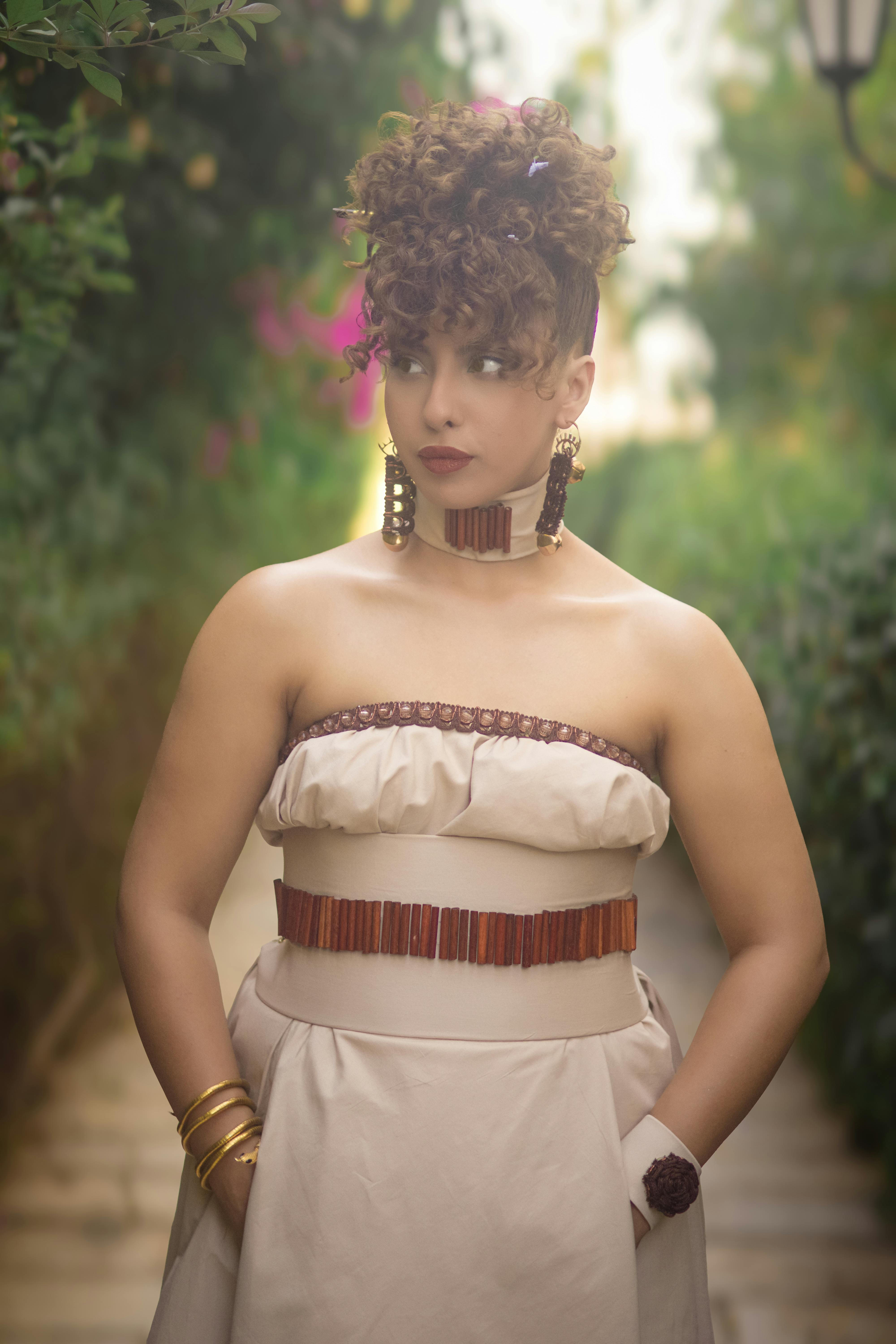 一位穿着优雅连衣裙的时尚女性的肖像，在突尼斯郁郁葱葱的花园环境中户外