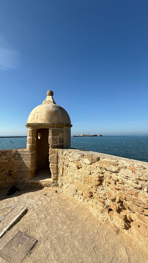 Free Scenic view of a Torreón in Cádiz, Spain, showcasing the ancient architecture against a clear blue sea and sky. Stock Photo