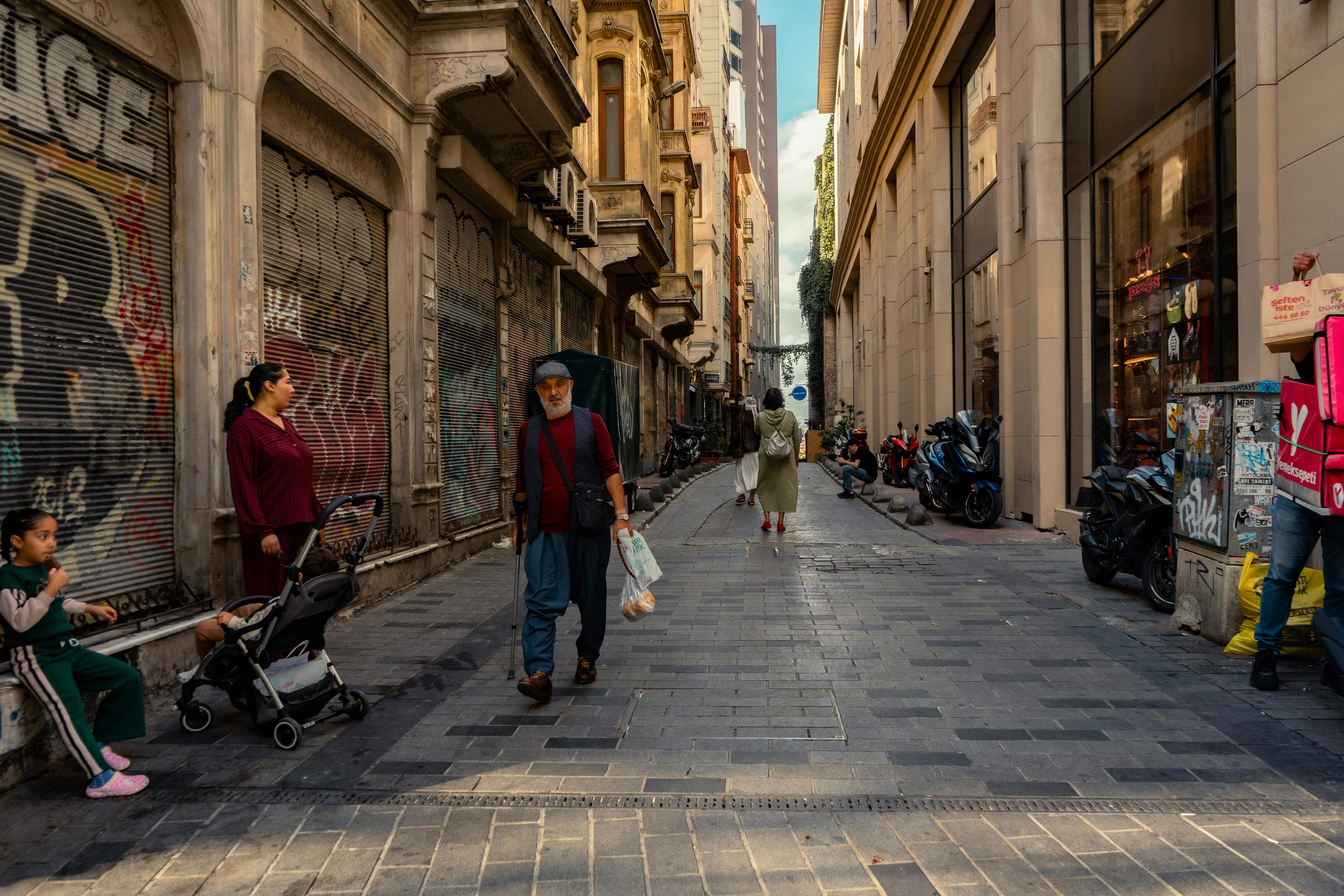A bustling urban alleyway with diverse pedestrians in a historic city street.