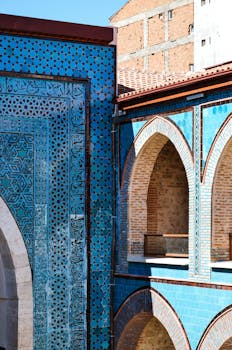 Stunning Seljuk architecture featuring turquoise tile patterns and intricate stonework in a bright courtyard.