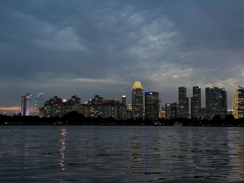 Free Beautiful view of the Singapore skyline at dusk with city lights reflecting on the water. Stock Photo