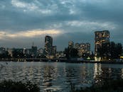 在黄昏时，城市天际线映照在河水上，与照明的建筑物交相辉映