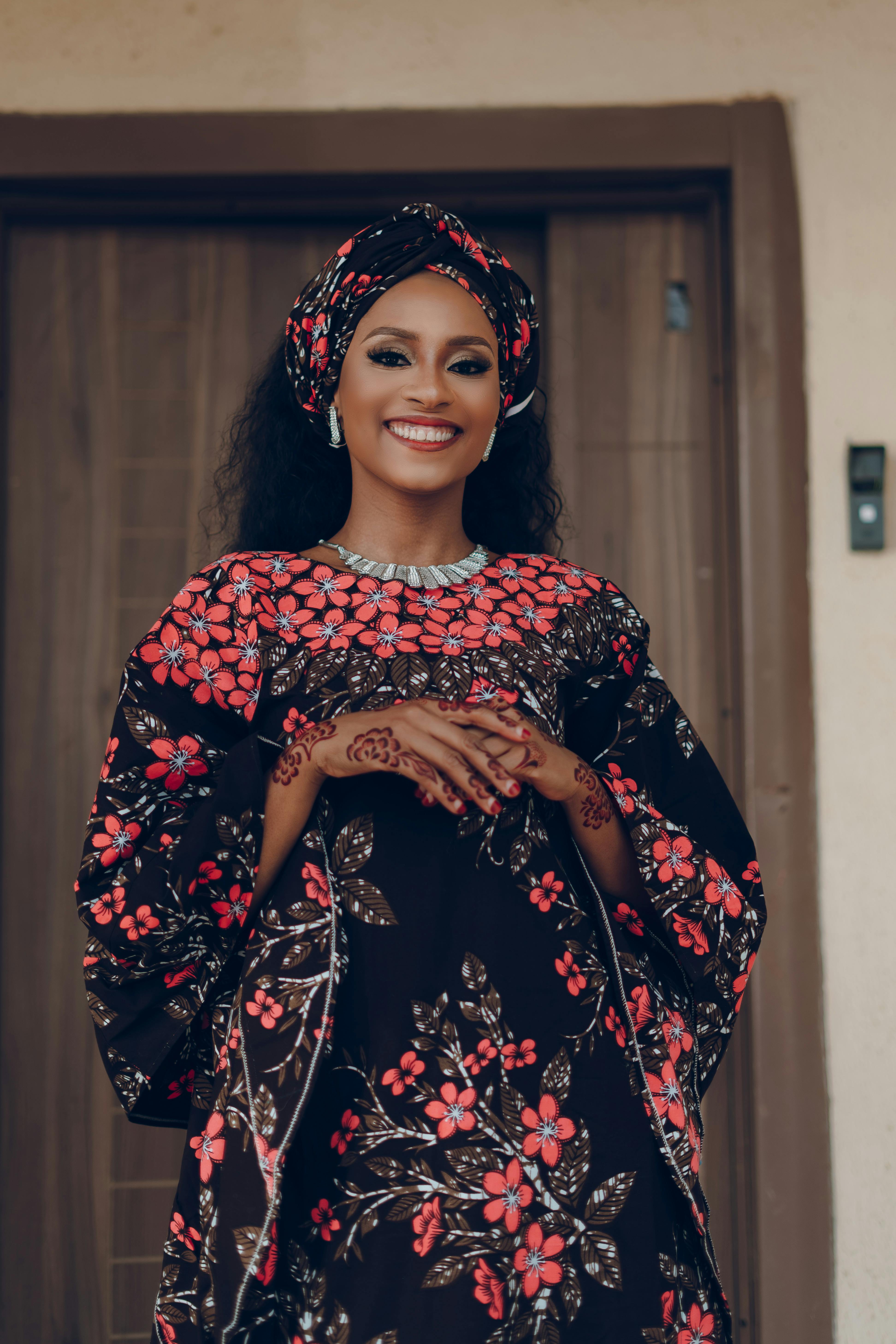 身着充满活力的传统非洲花卉图案连衣裙的女人微笑着