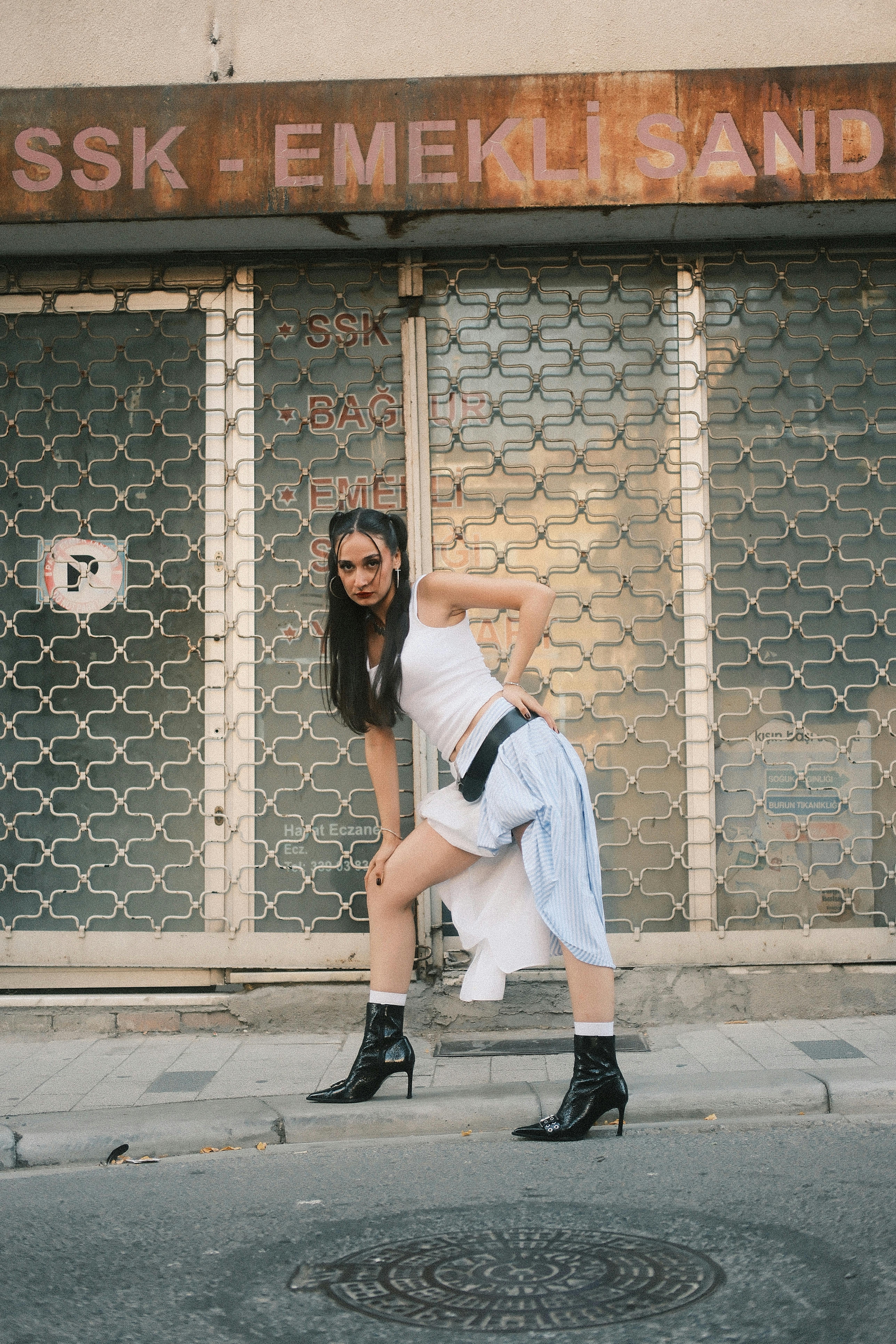 Modern urban fashion pose in front of closed shop. Confidence and trend-setting vibe.