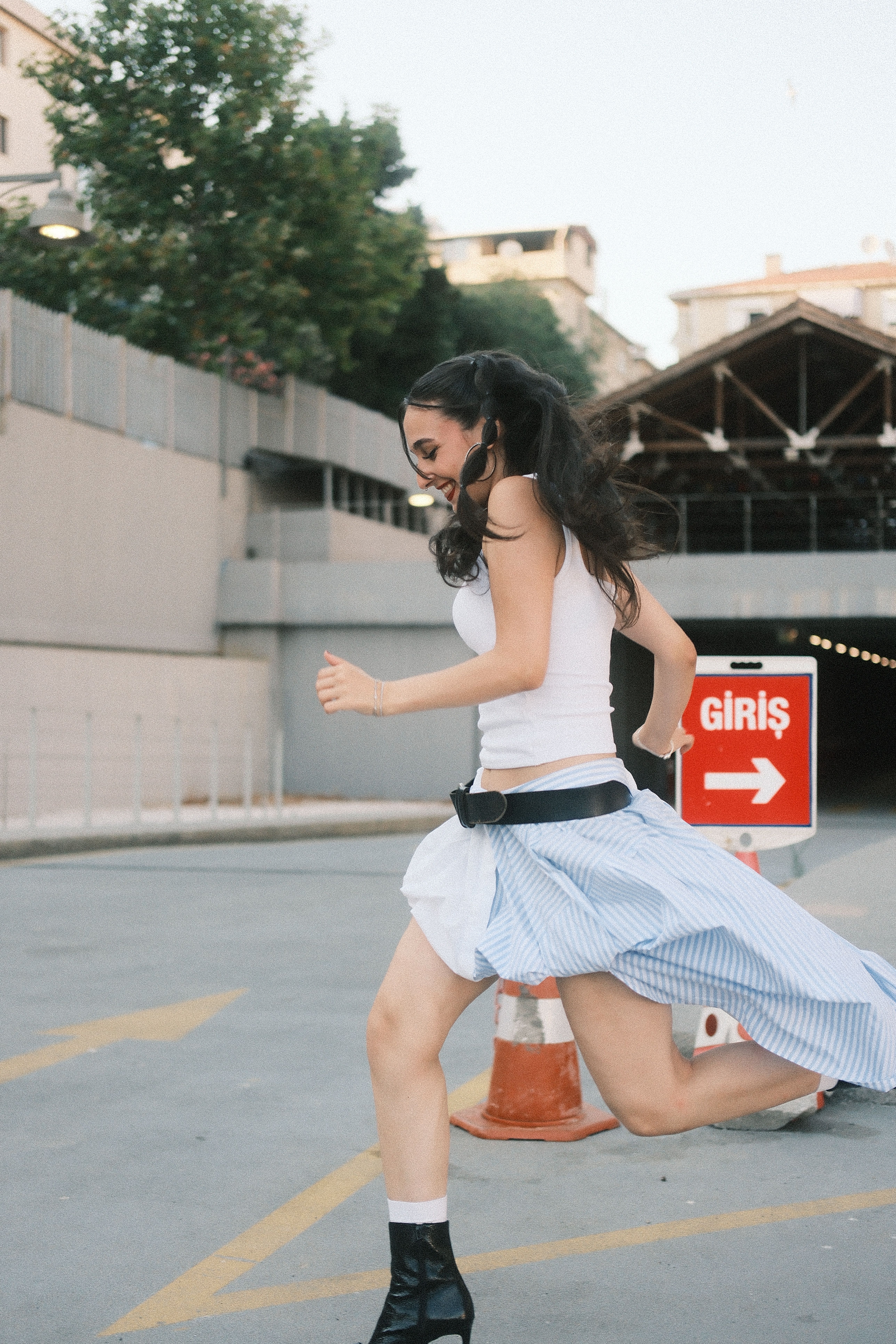 A woman in motion runs by a sign that says 'Giriş' near an urban tunnel.