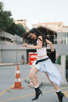 在阳光明媚的日子里，一位年轻女子正在积极地跳过城市交通锥附近