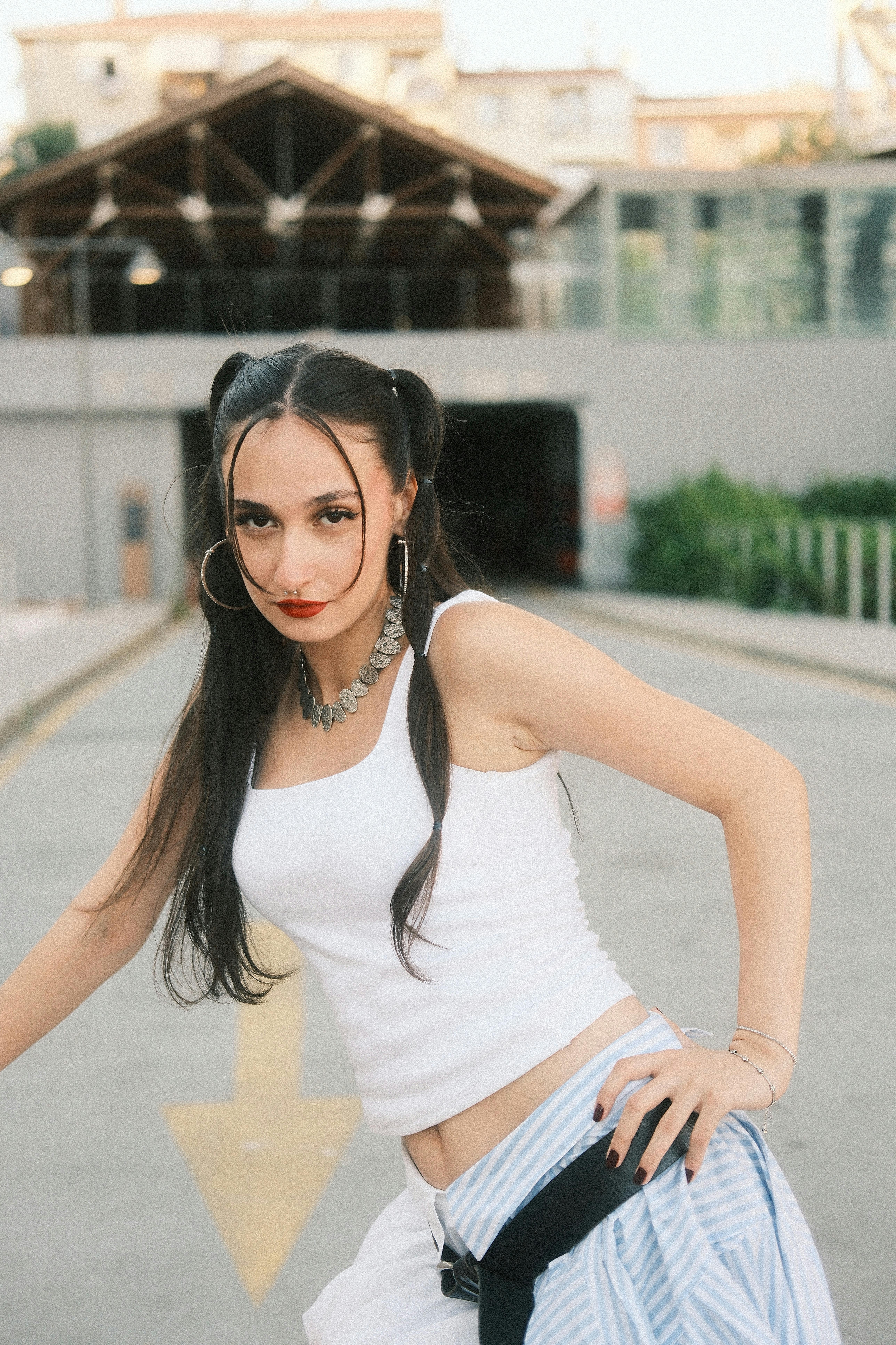 Stylish young woman with long hair poses confidently outdoors.