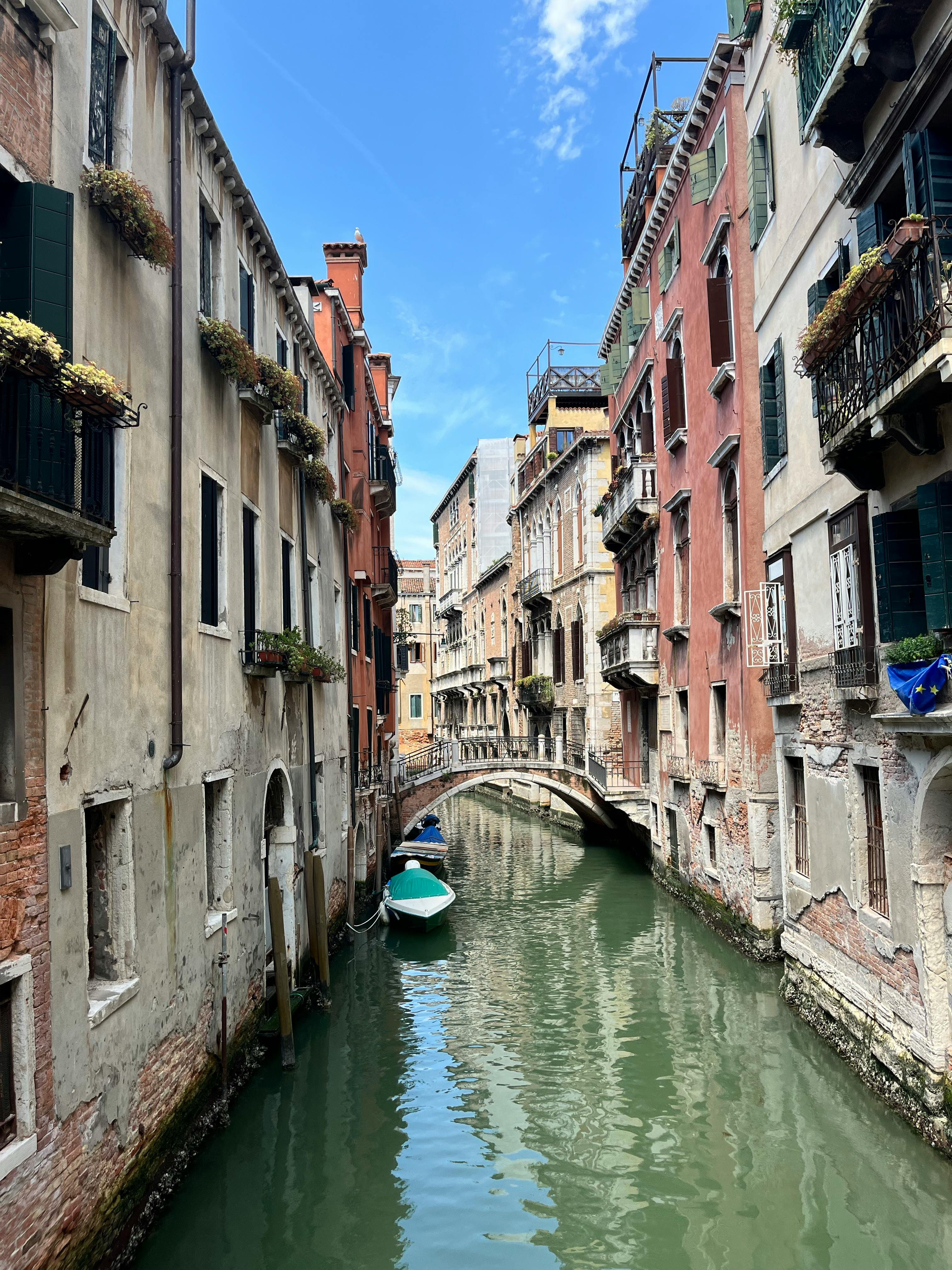 迷人的威尼斯运河，拥有色彩缤纷的历史建筑和蓝天下的小船