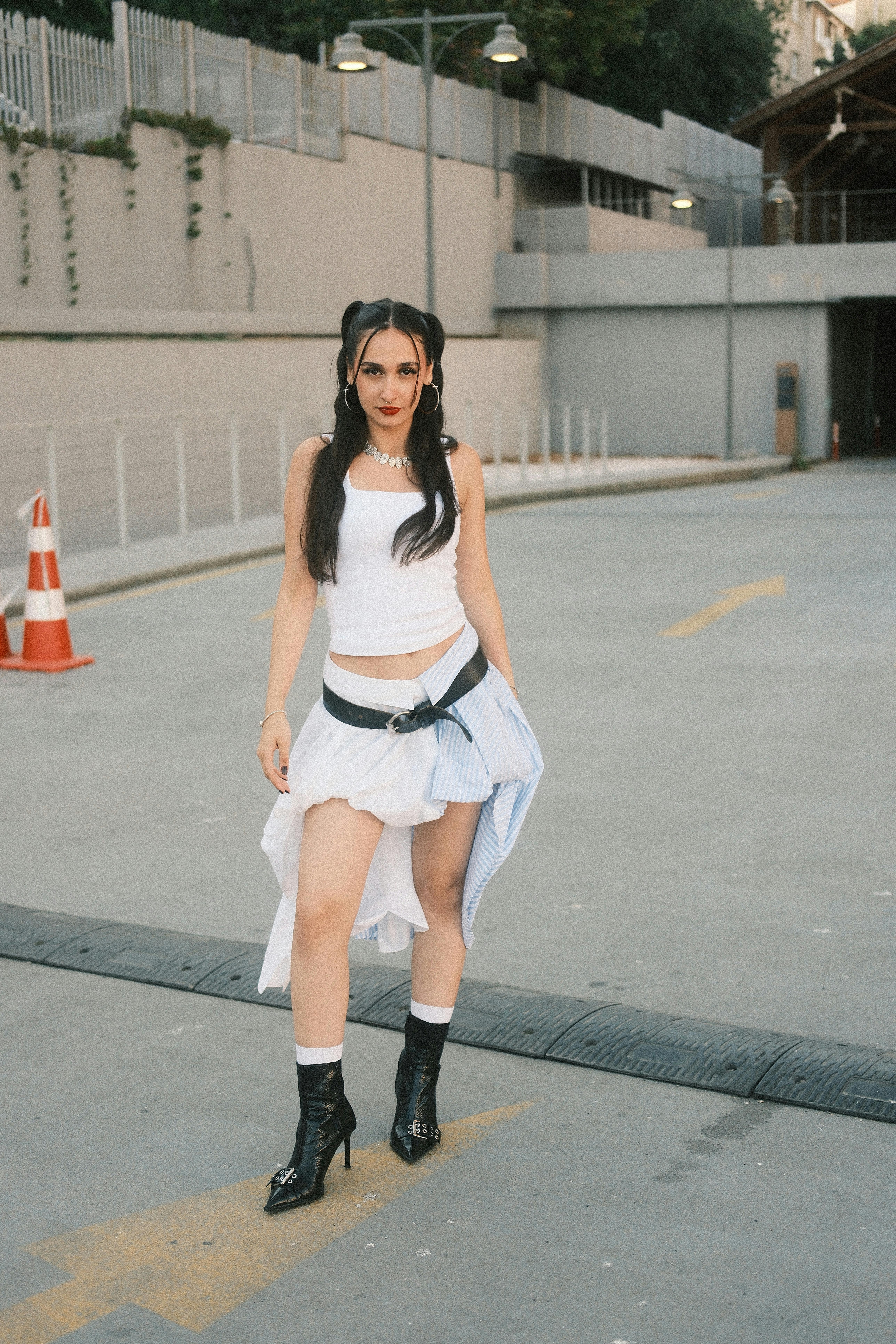 Young woman in stylish outfit on city street. Urban fashion vibe outdoors.