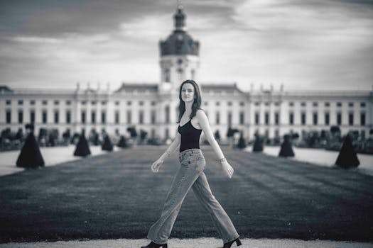 一位女士在柏林夏洛滕堡宫前行走的黑白照片