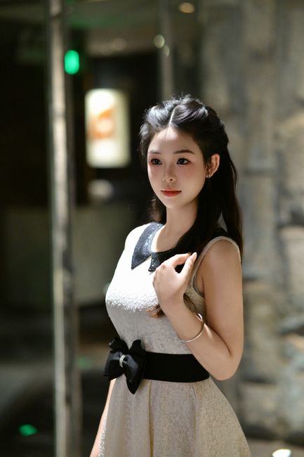 Portrait of a young woman in a fashionable dress indoors, exuding elegance and grace.