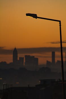 在日落时分，街灯的轮廓勾勒出城市天际线，营造出喜怒无常的艺术氛围