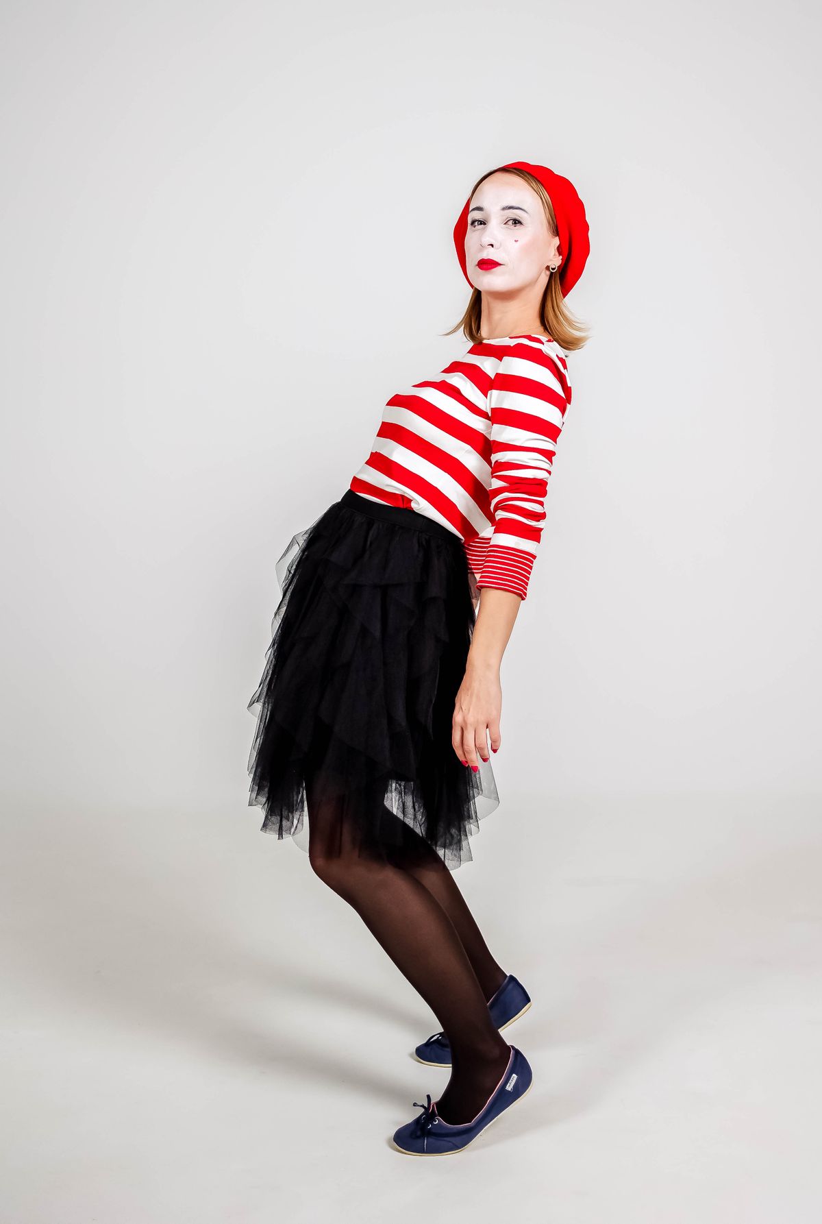 A playful mime artist gesturing in costume, acting out a clue, party games for adults without alcohol