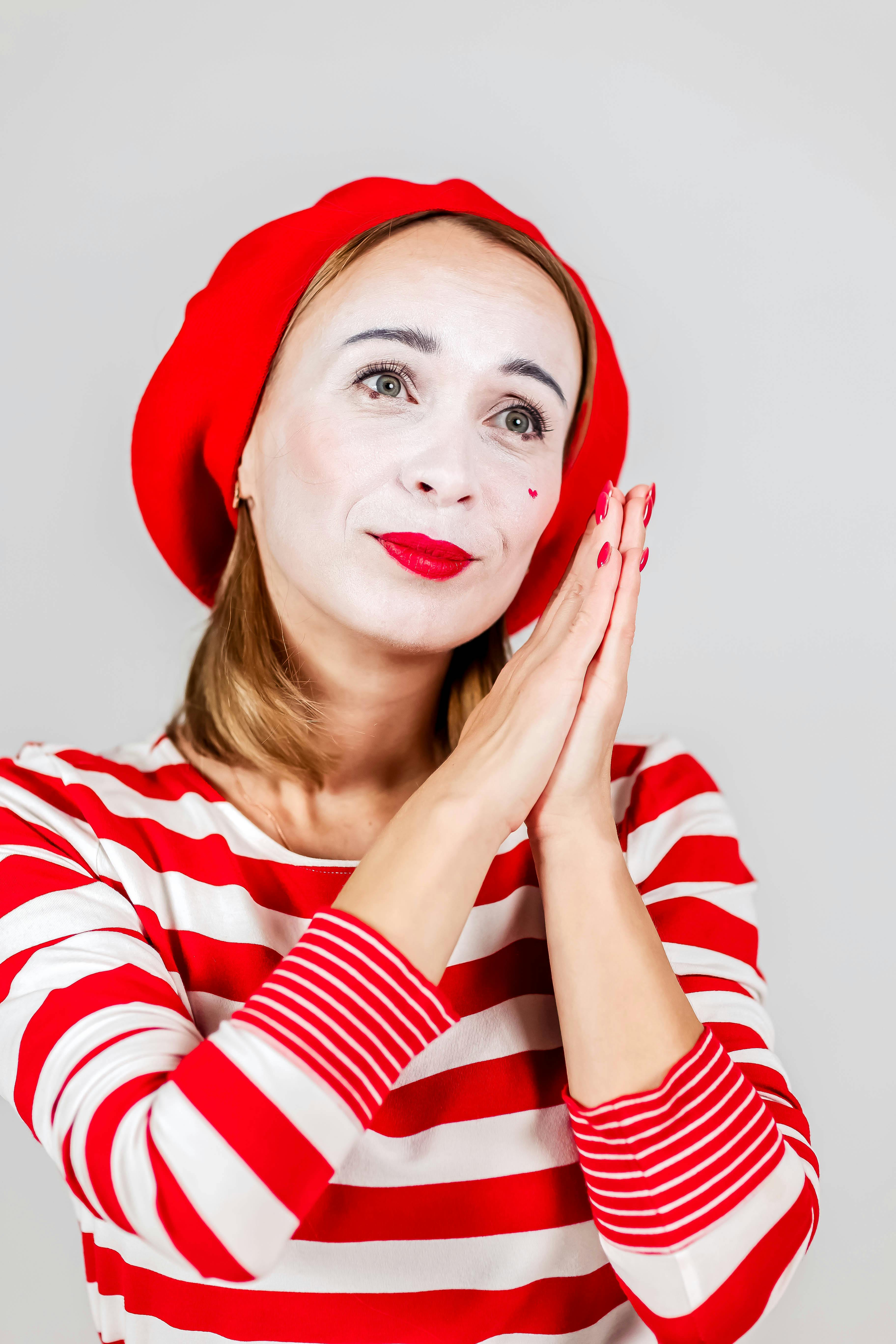 Gratis Retrato de un mimo con rayas rojas y blancas y pose pensativa. Foto de stock