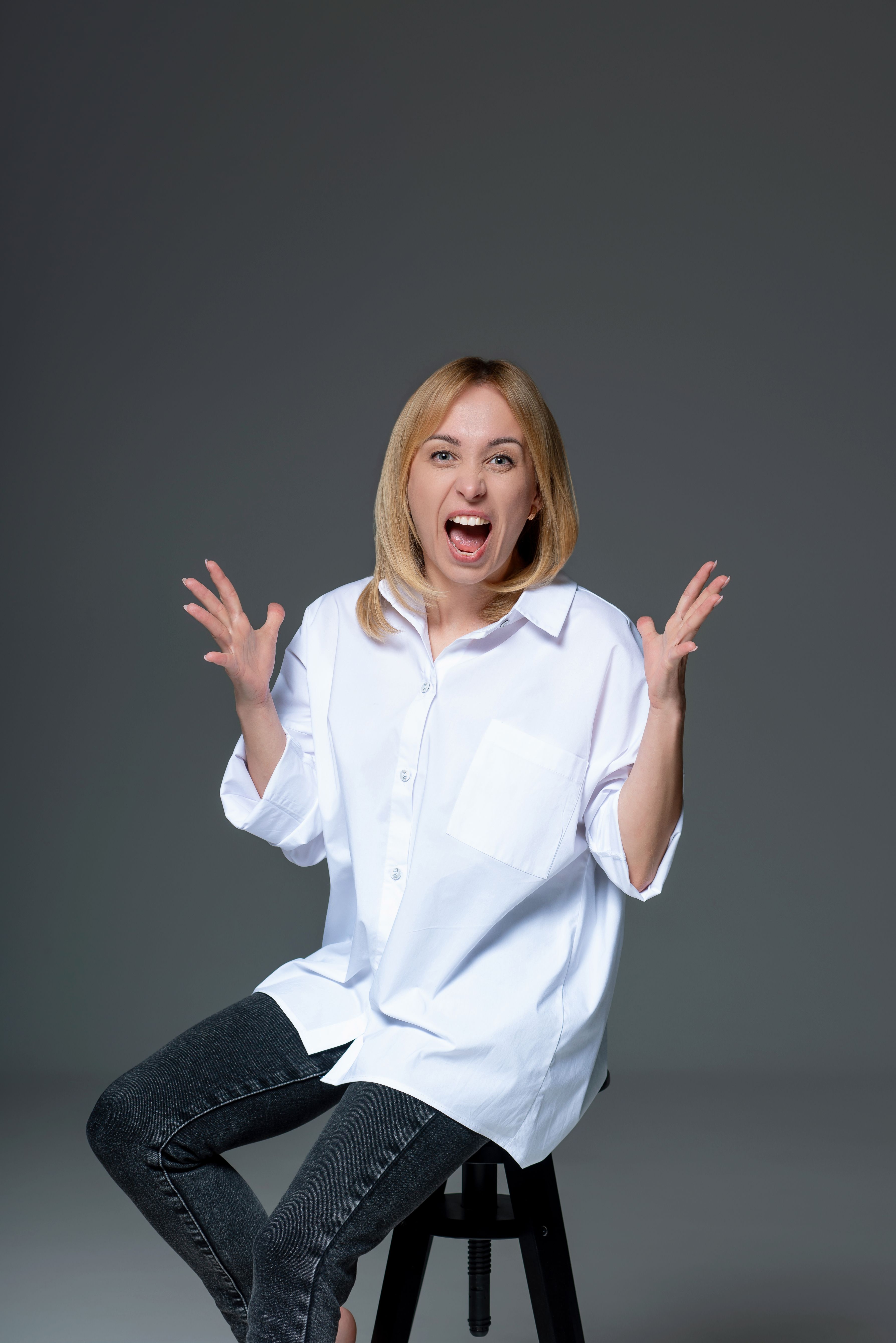 Expressive Woman in Casual Attire Against Dark Background · Free Stock ...