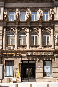 A classical architectural facade featuring statues in Bucharest, Romania under bright daylight.