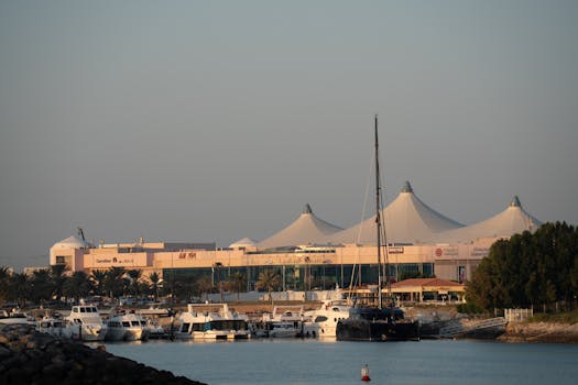 Scenic view of yachts anchored at Abu Dhabi's Marina with Marina Mall in the background at sunrise.