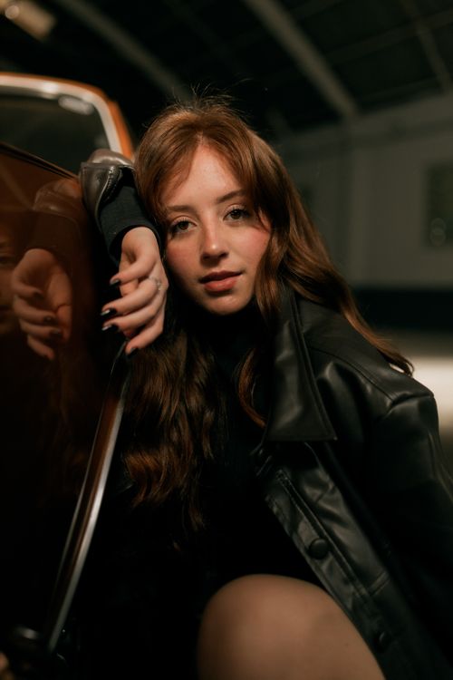 Free Close-up portrait of a young woman in a leather jacket indoors. Stock Photo