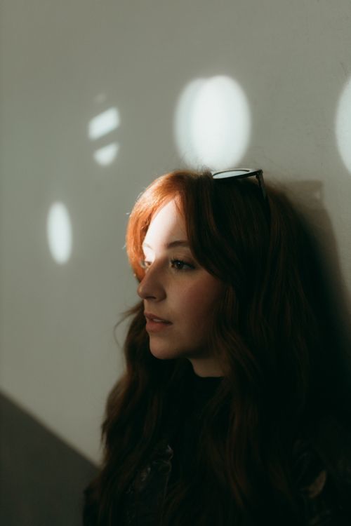 Free Profile of a woman lit by gentle indoor light, creating a serene and thoughtful ambiance. Stock Photo