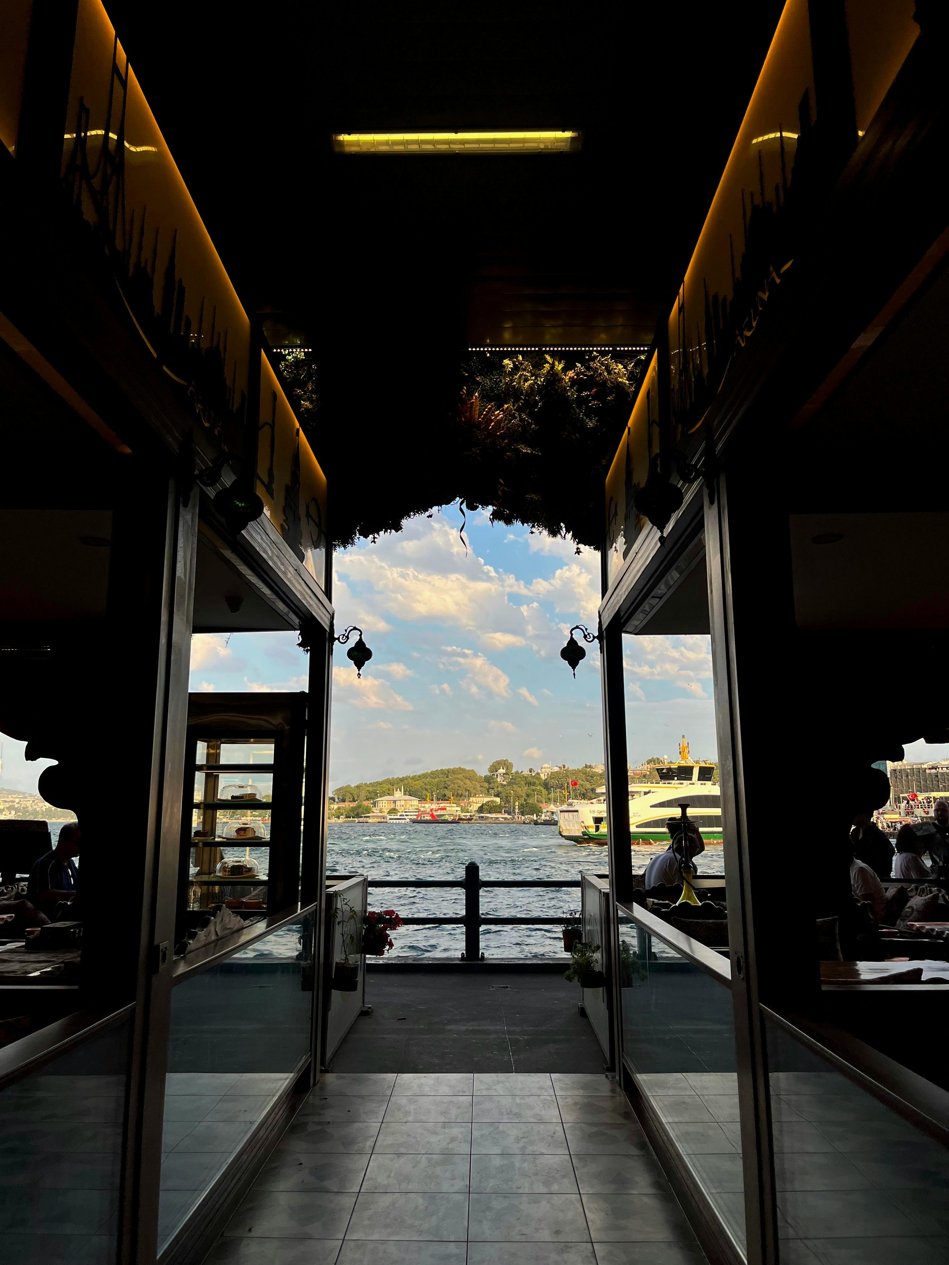 在一间时尚的室内餐厅中，通过一个充满活力的海滨视图，营造出一种轻松愉悦的氛围