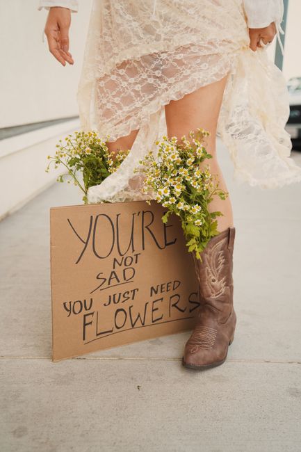 Lace dress and cowboy boots styled with wildflowers and an uplifting sign.