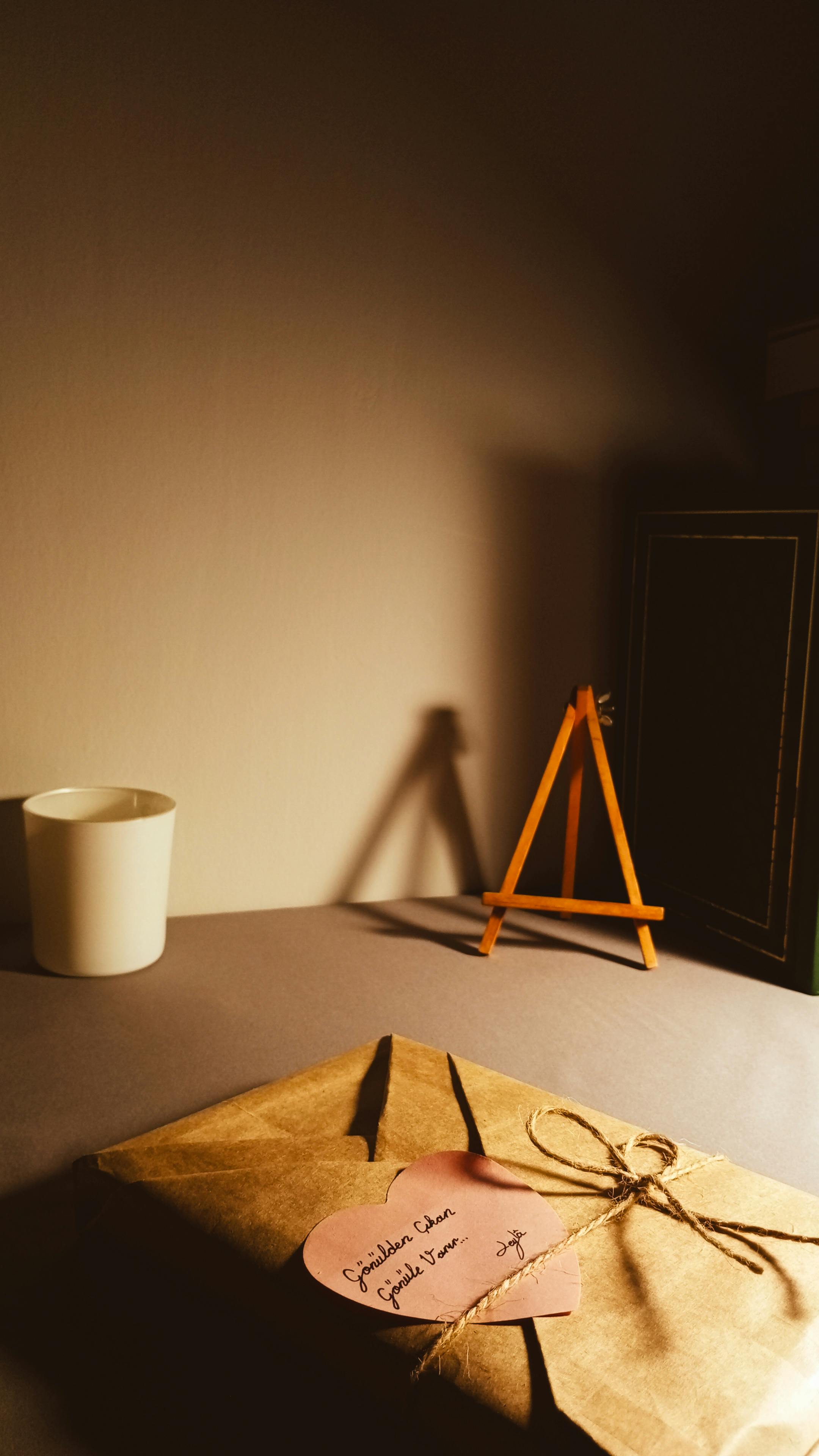 ingyenes Egy melegen megvilágított jelenet egy becsomagolt ajándékról, szív alakú címkével egy faasztalon, ideális ünnepléshez. Stockfotó