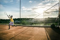 捕捉年轻运动员在室外网球场上日落时表演的强度