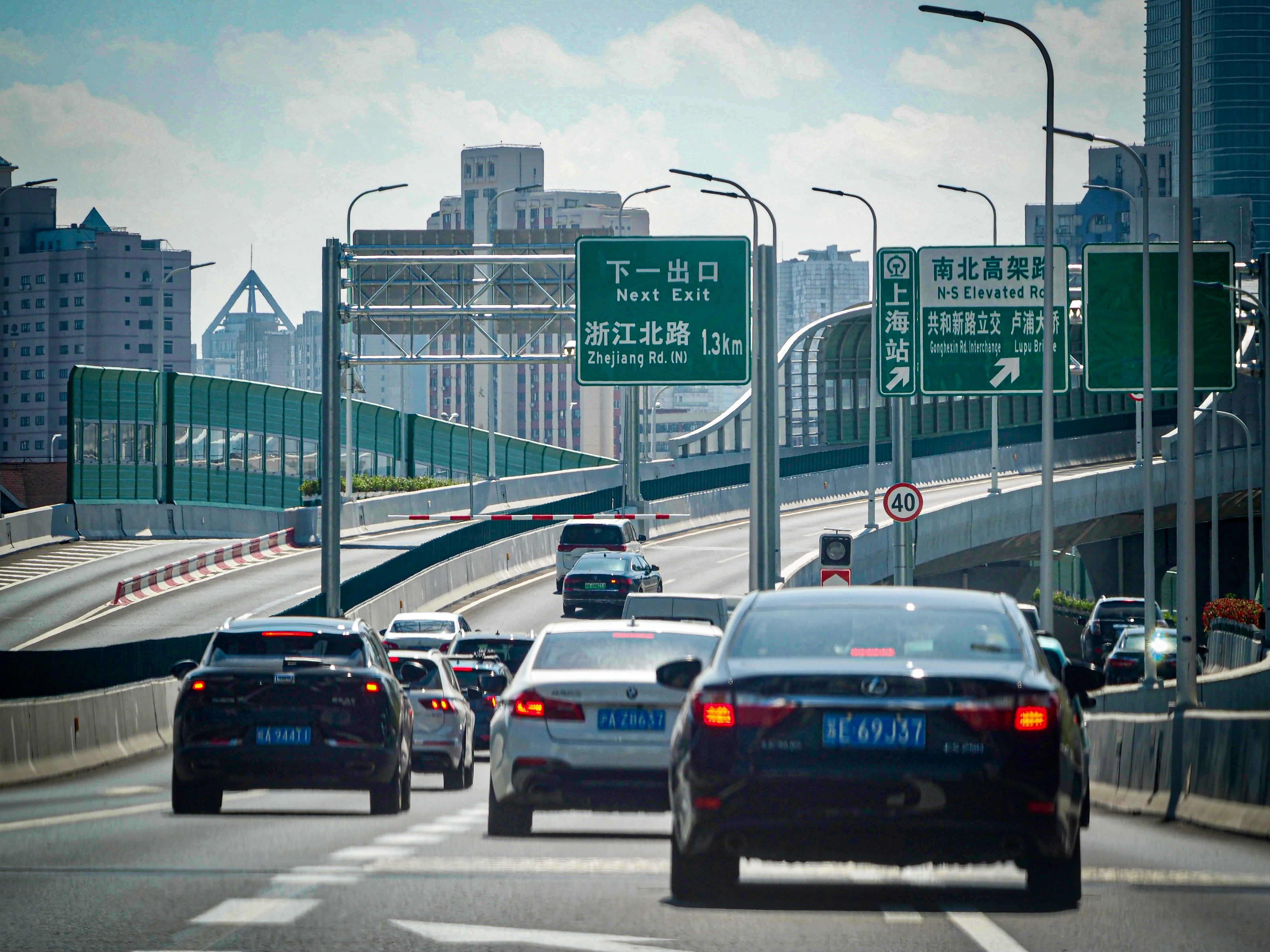 汽车在高架高速公路上穿行，经过上海的城市景观