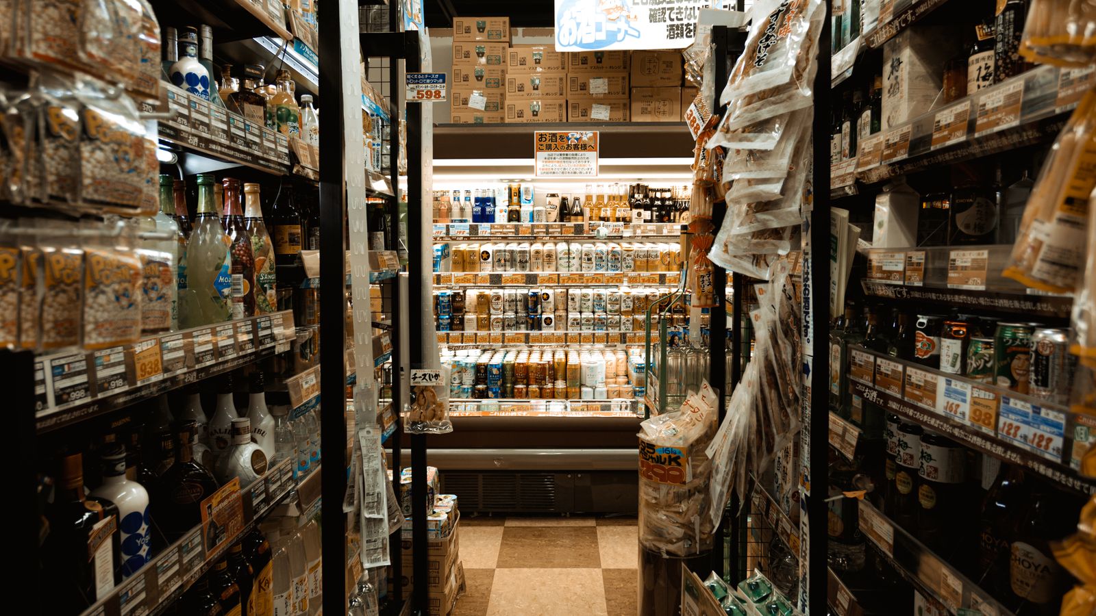 Explore a bustling Tokyo convenience store aisle packed with diverse products and merchandise.