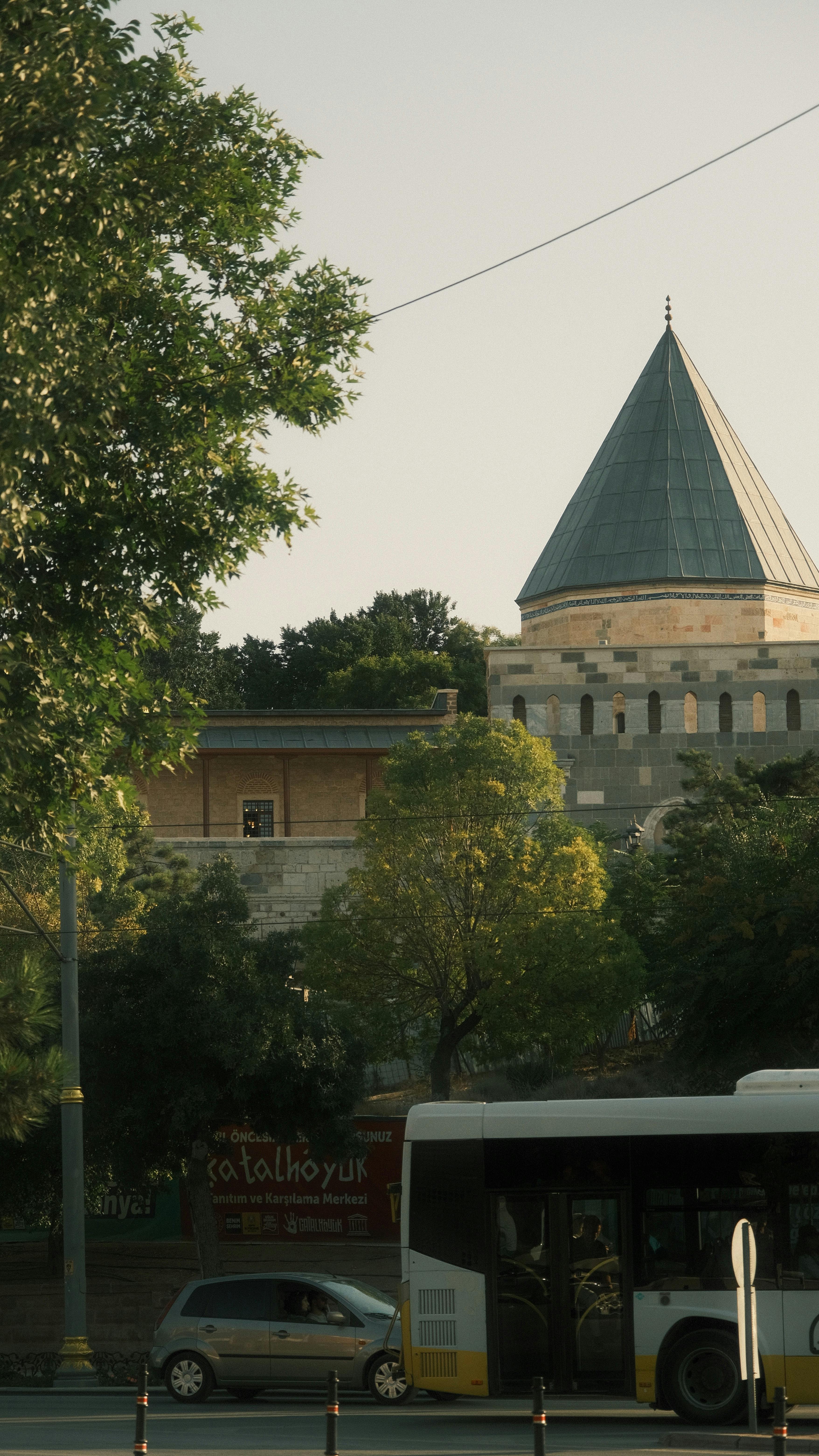 一辆城市巴士在晴朗的天空下经过，周围是郁郁葱葱的绿色植物