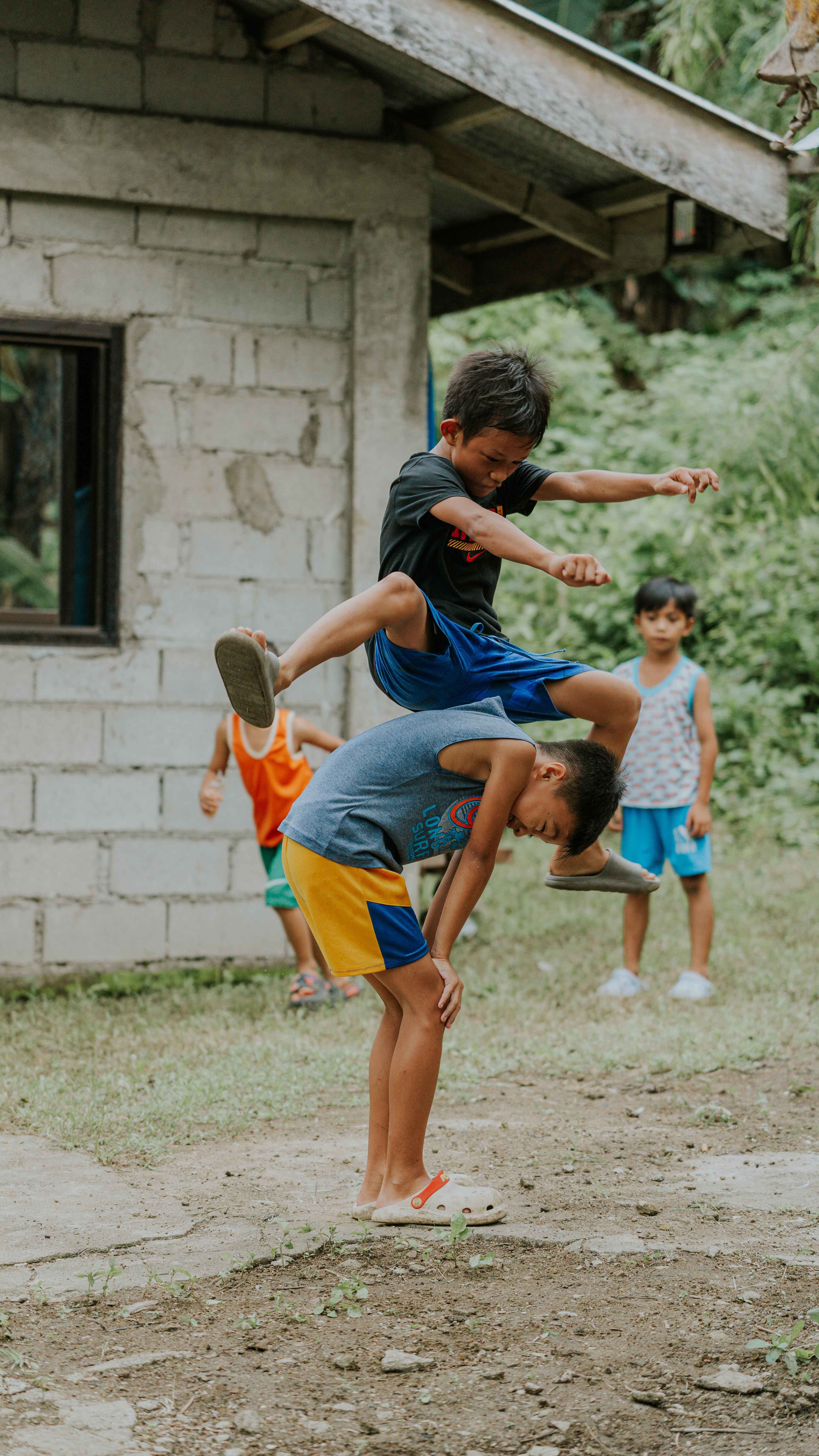 Kids enjoy traditional games outdoors in a rural setting, capturing vibrant childhood moments.