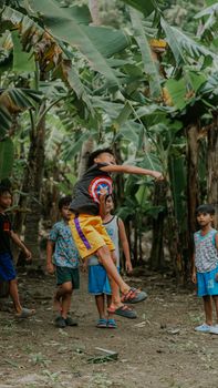 Group of children enjoying playtime in a tropical banana grove, full of energy and joy.