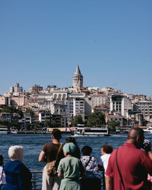Free A scenic view of people enjoying the Galata Tower from the waterfront in Istanbul, Turkey. Stock Photo