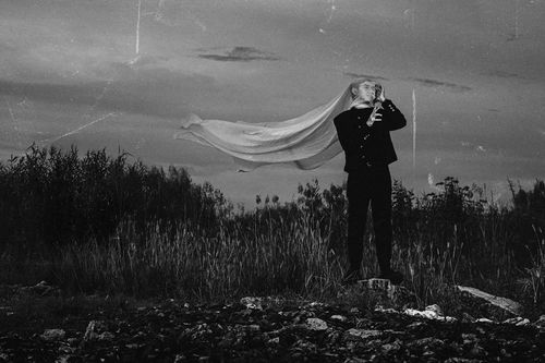 Free A dramatic black and white portrait featuring a person with flowing fabric outdoors. Stock Photo