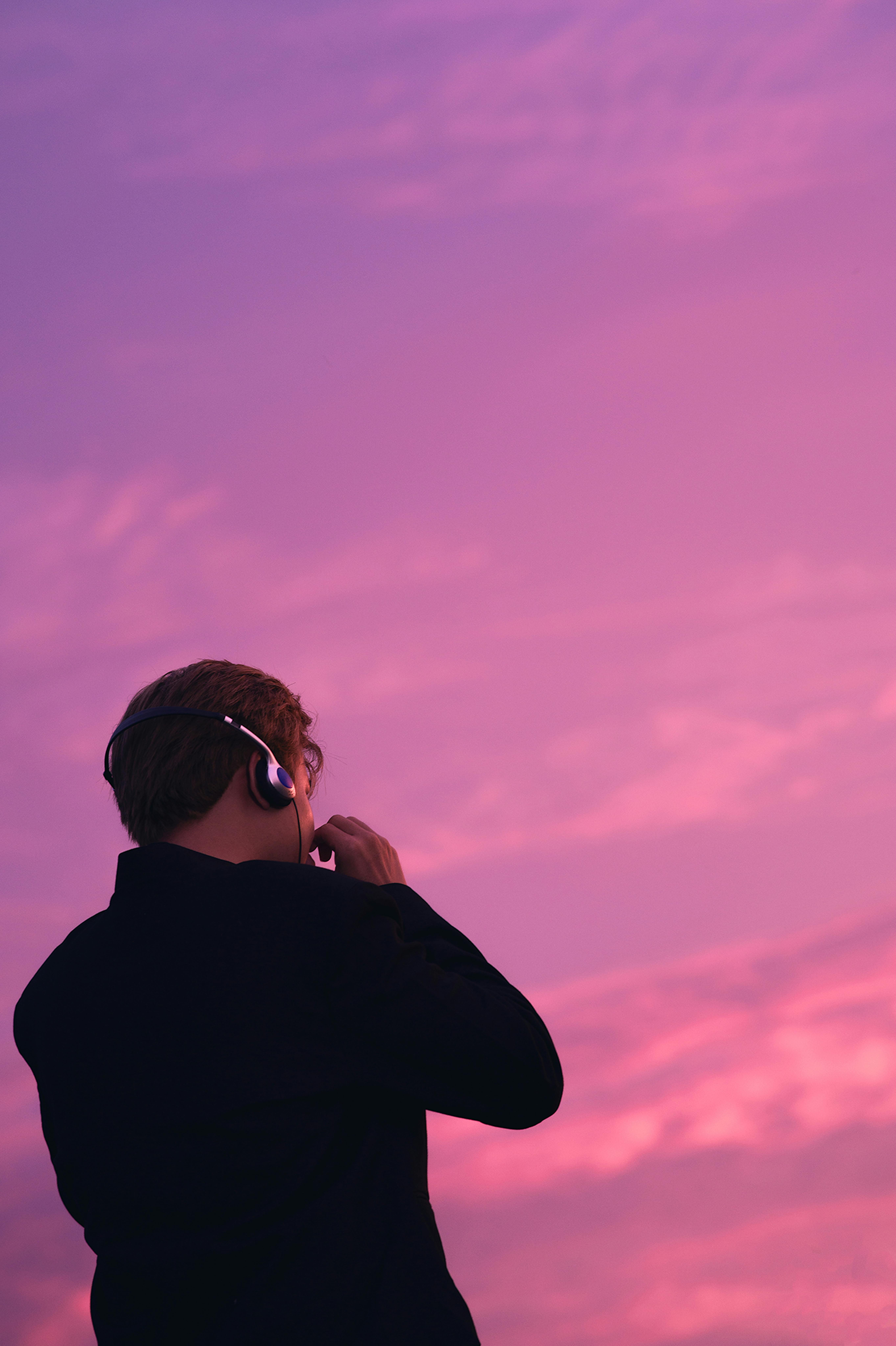 Kostenlos Silhouette einer Person, die vor dem Hintergrund eines leuchtend rosa Sonnenuntergangs in Đồng Tháp, Vietnam, Musik genießt. Stock-Foto
