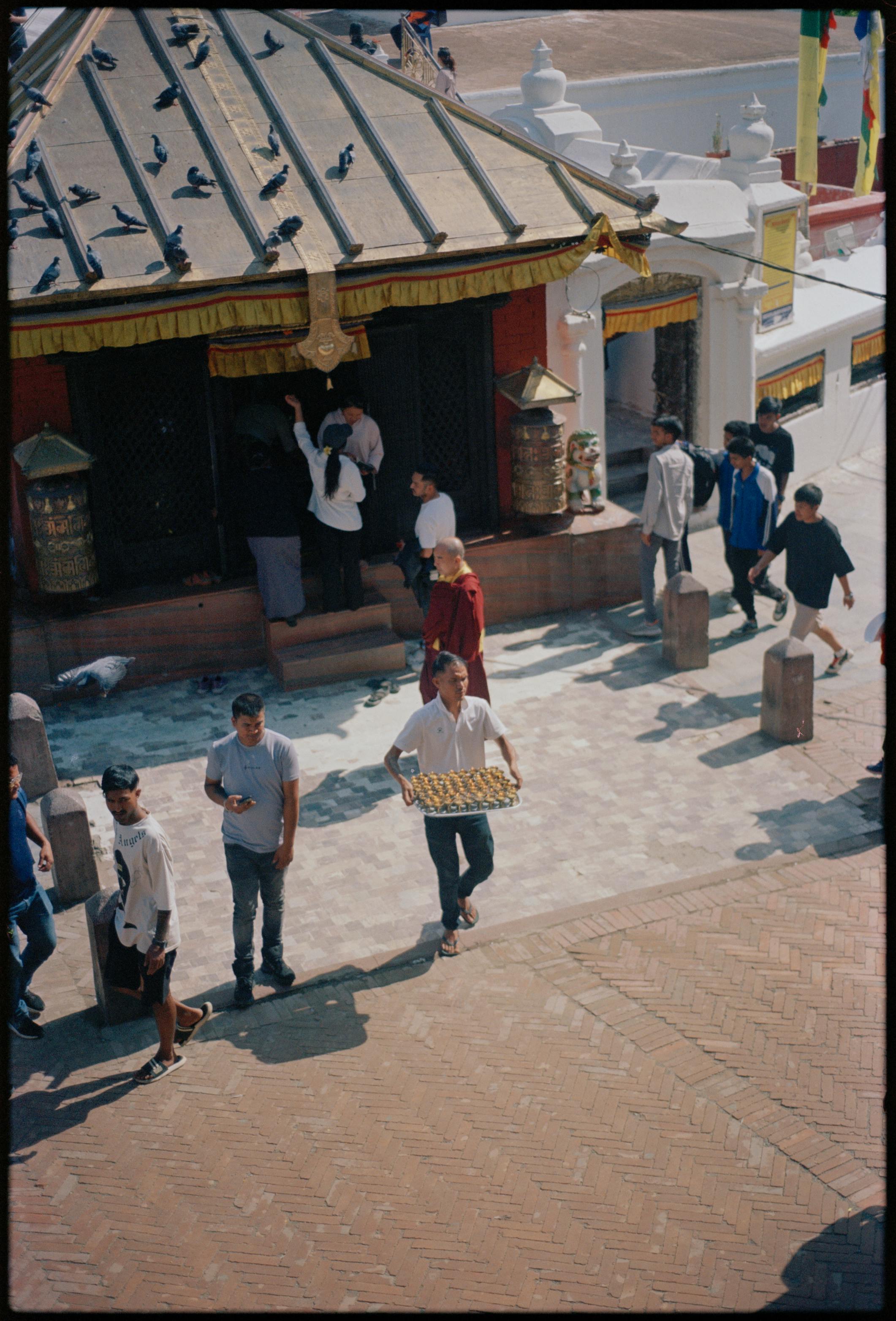 Ücretsiz Güneşli bir günde, bir tapınağın dışında ibadet edenlerin hareketliliğinin havadan görüntüsü. Stok Fotoğraflar
