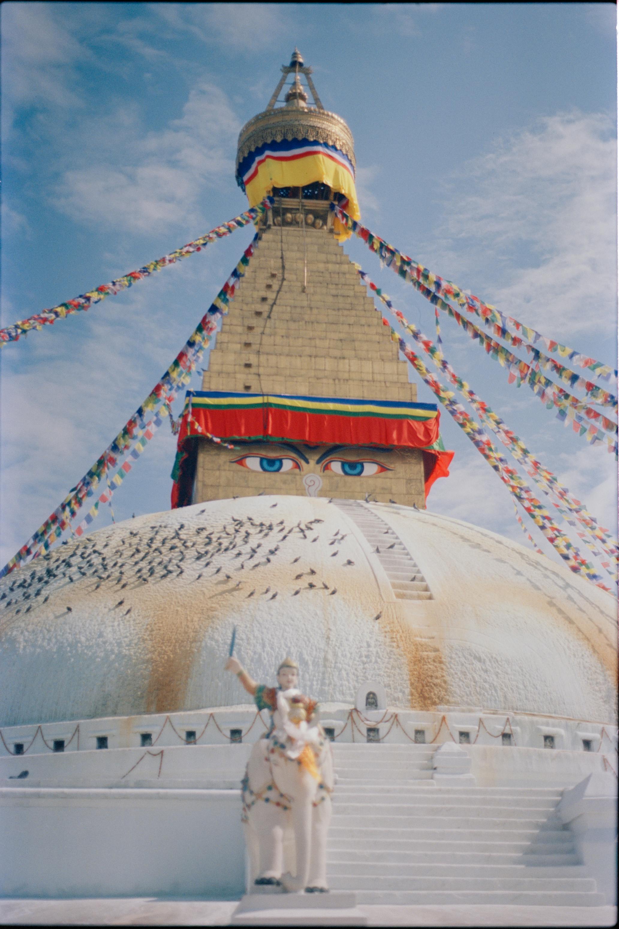布达纳特佛塔，位于尼泊尔加德满都，挂着祈祷旗帜，天空晴朗