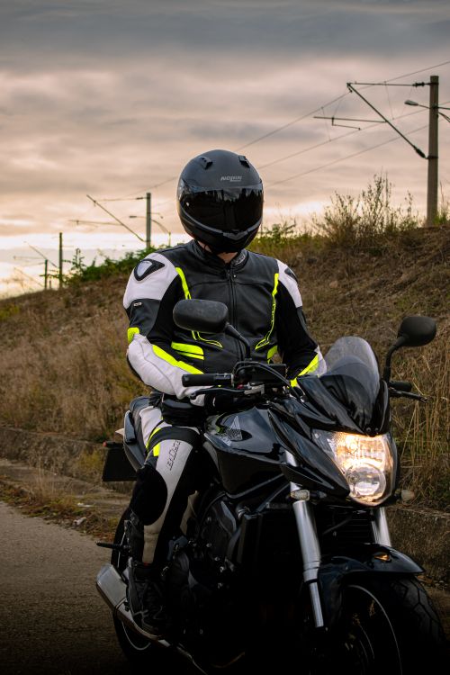 Free Rider on black sport motorcycle with gear under cloudy sky. Stock Photo