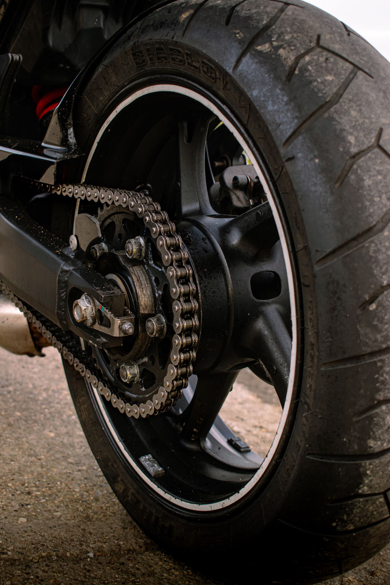 Vue rapprochée de la roue arrière et de la chaîne d'une moto