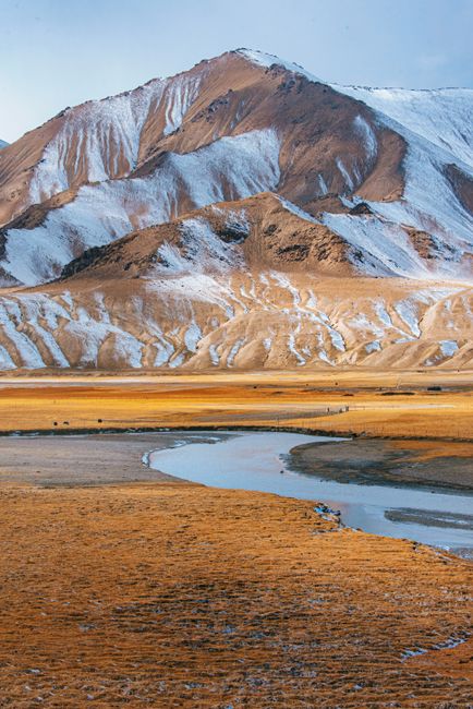 Breathtaking view of snow-capped mountain with a serene river, in early winter.