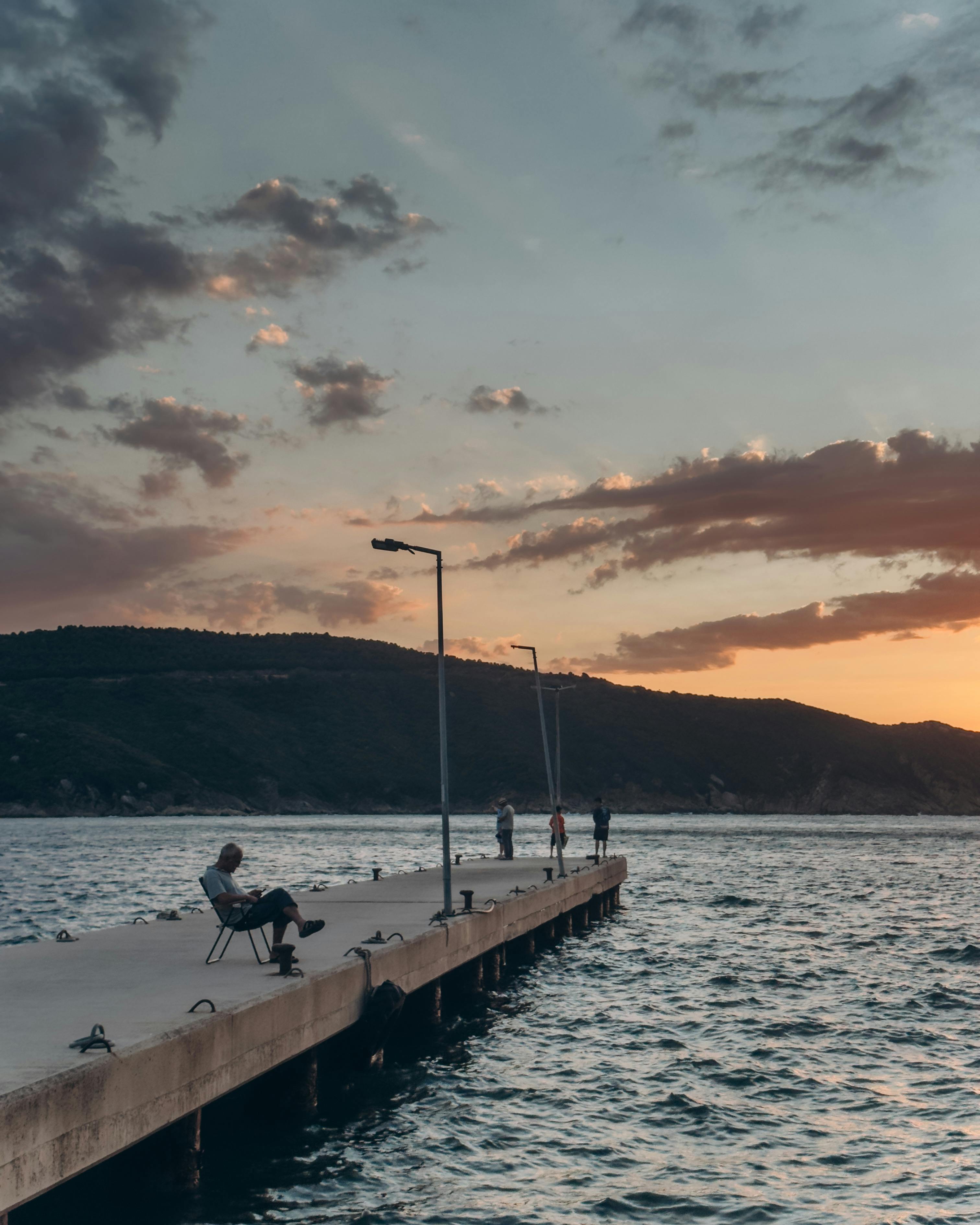 在风景如画的日落时分，人们在码头上放松身心