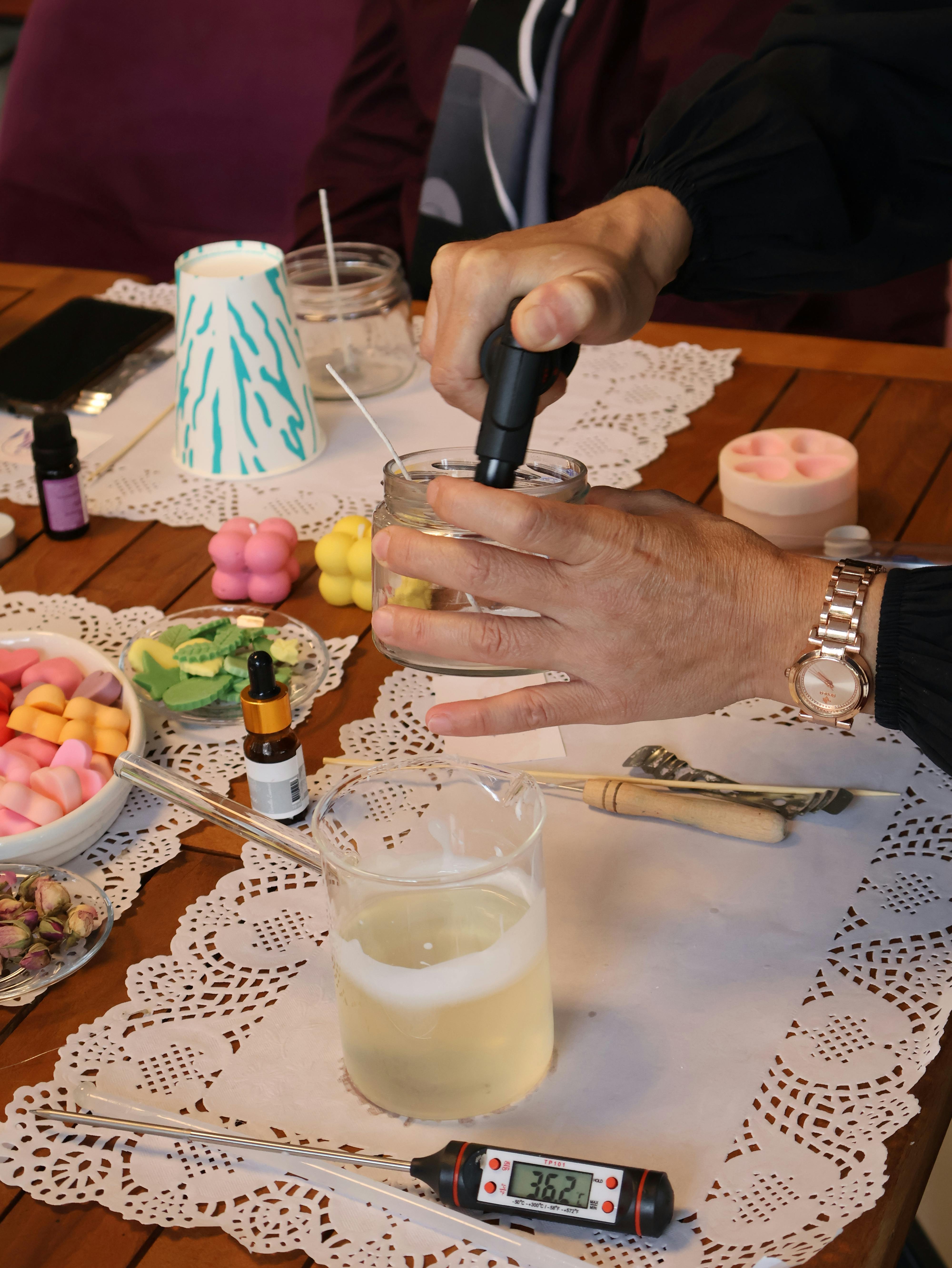 Handcrafting candles with essential oils and wax in a creative workshop setting.