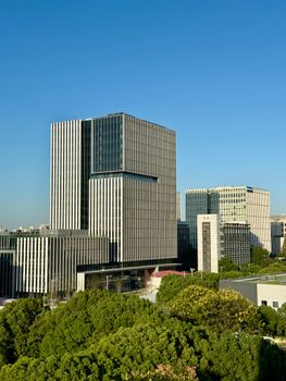 Aerial view of modern skyscrapers in Shanghai under a clear blue sky.