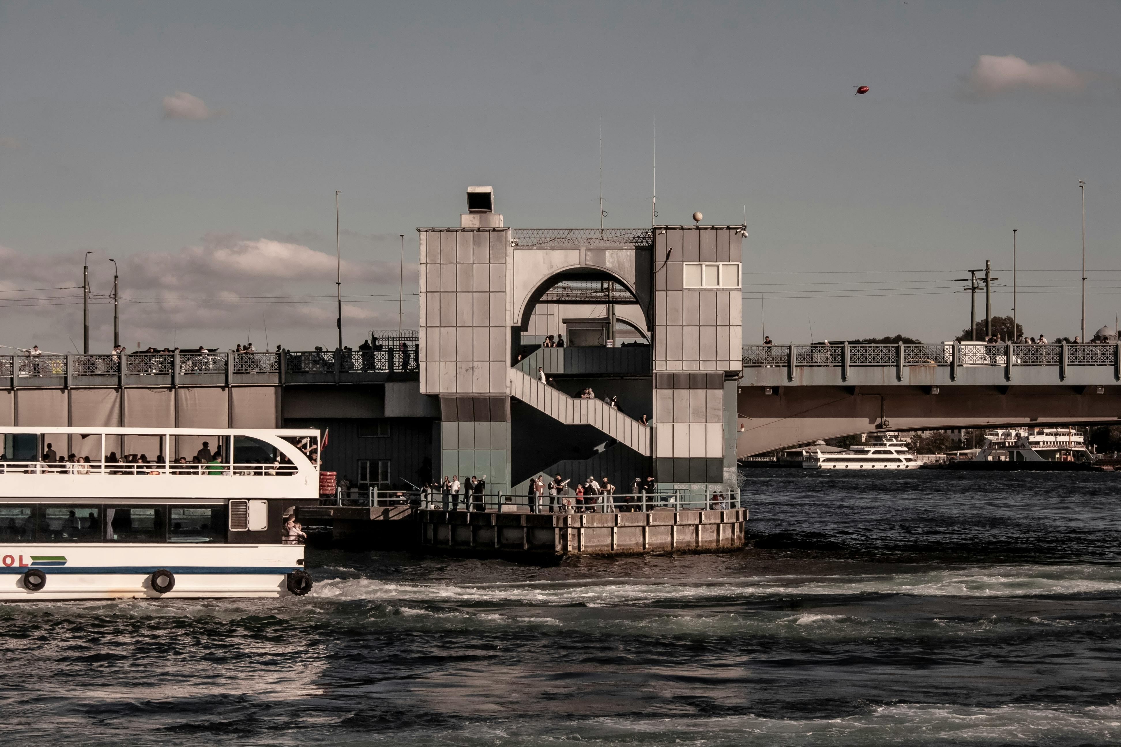 现代桥梁横跨繁忙的河流，城市景观环境中有船只和人员