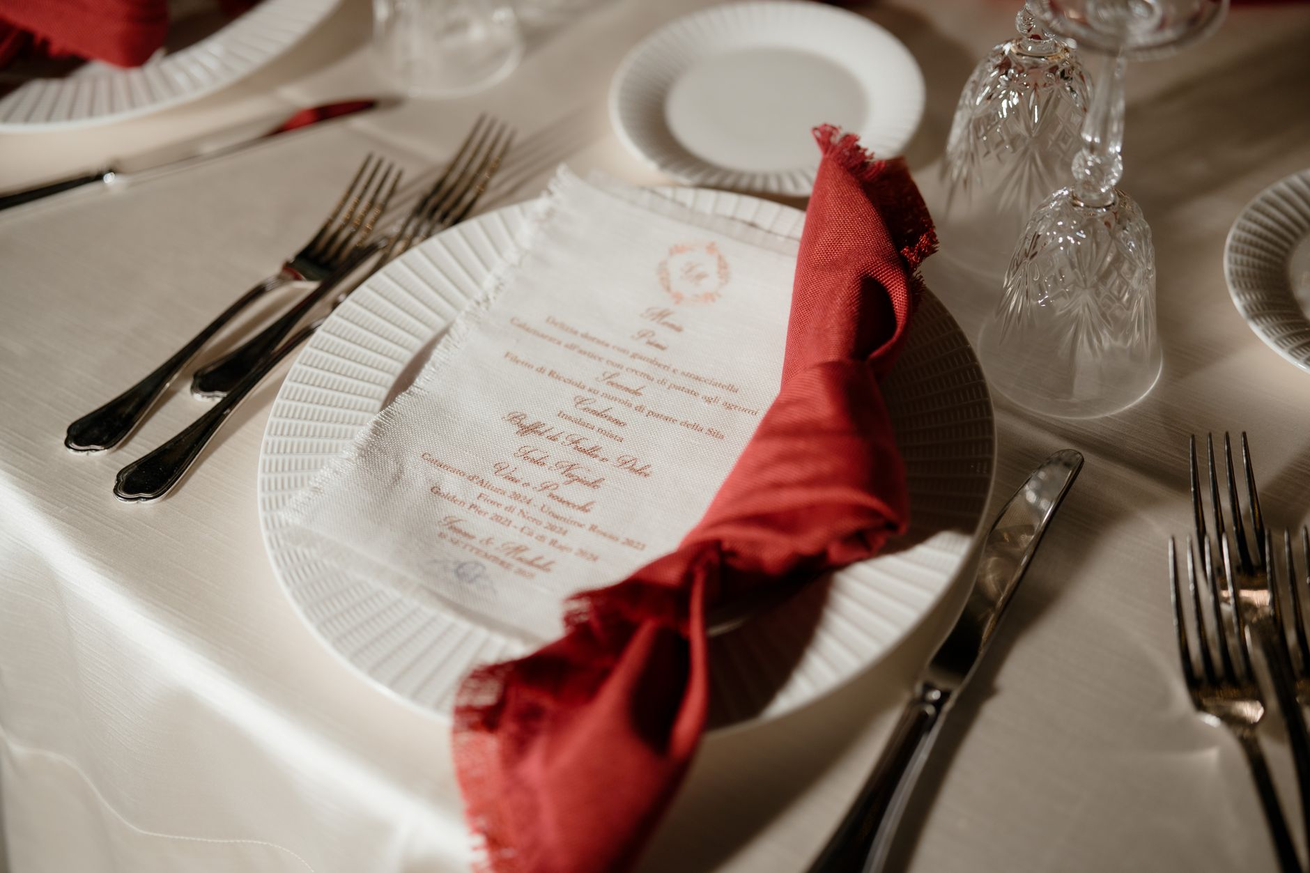 Close-up of an elegantly set table with a red napkin and menu, perfect for weddings or formal events.