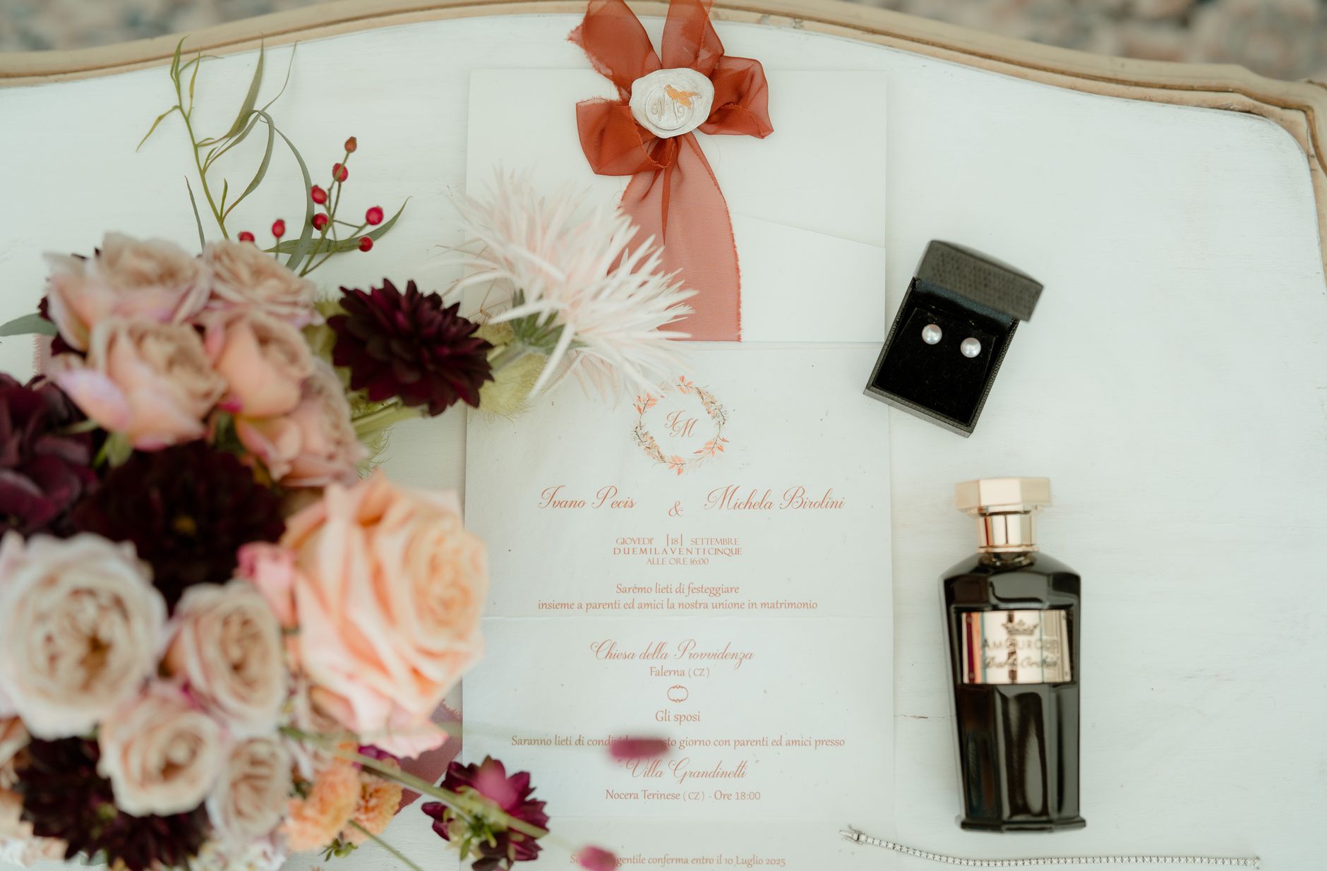 Flat lay élégant d’une invitation de mariage avec fleurs, parfum et bijoux